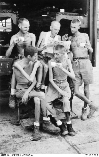Five Australian former POWs relax with cups of tea and a newspaper after the Japanese surrender. Their thin bodies show the physical effects of captivity. (Courtesy of the Australian War Memorial