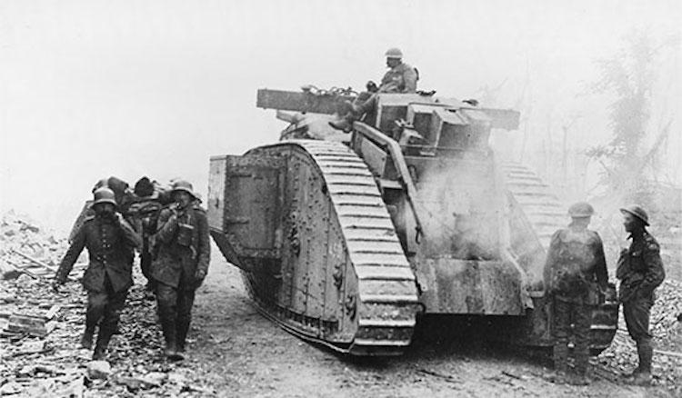 A British tank moving forward after the Battle of Amiens passing a group of German POW carrying a wounded man on a stretcher, 10 August 1918. Courtesy of the Mary Evans and Robert Hunt Collection at the Imperial War Museum
