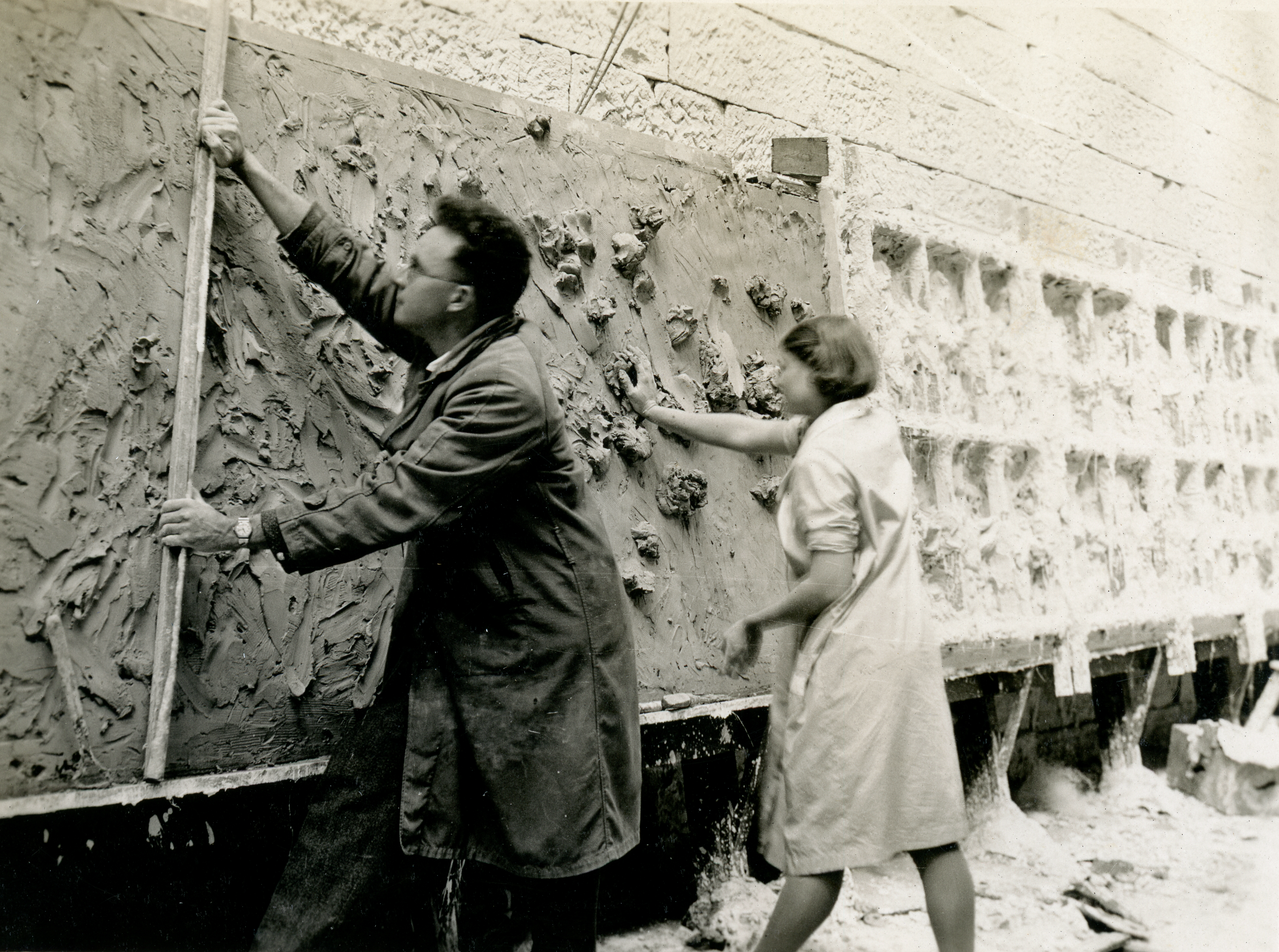 Arthur Buist and Barbara Tribe  applying clay to the bas releif backing board. Courtesy Sylvia Embling archive