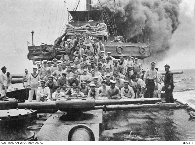 Members of the crew of HMAS Sydney pose on the forecastle while the cruiser is in pursuit of the collier Buresk (Emden’s support ship) near Cocos Island, 9 November 1914. The amount of funnel smoke shows Sydney is travelling at speed. Damage to the forebridge from the Emden action earlier that day is evident. Courtesy AWM