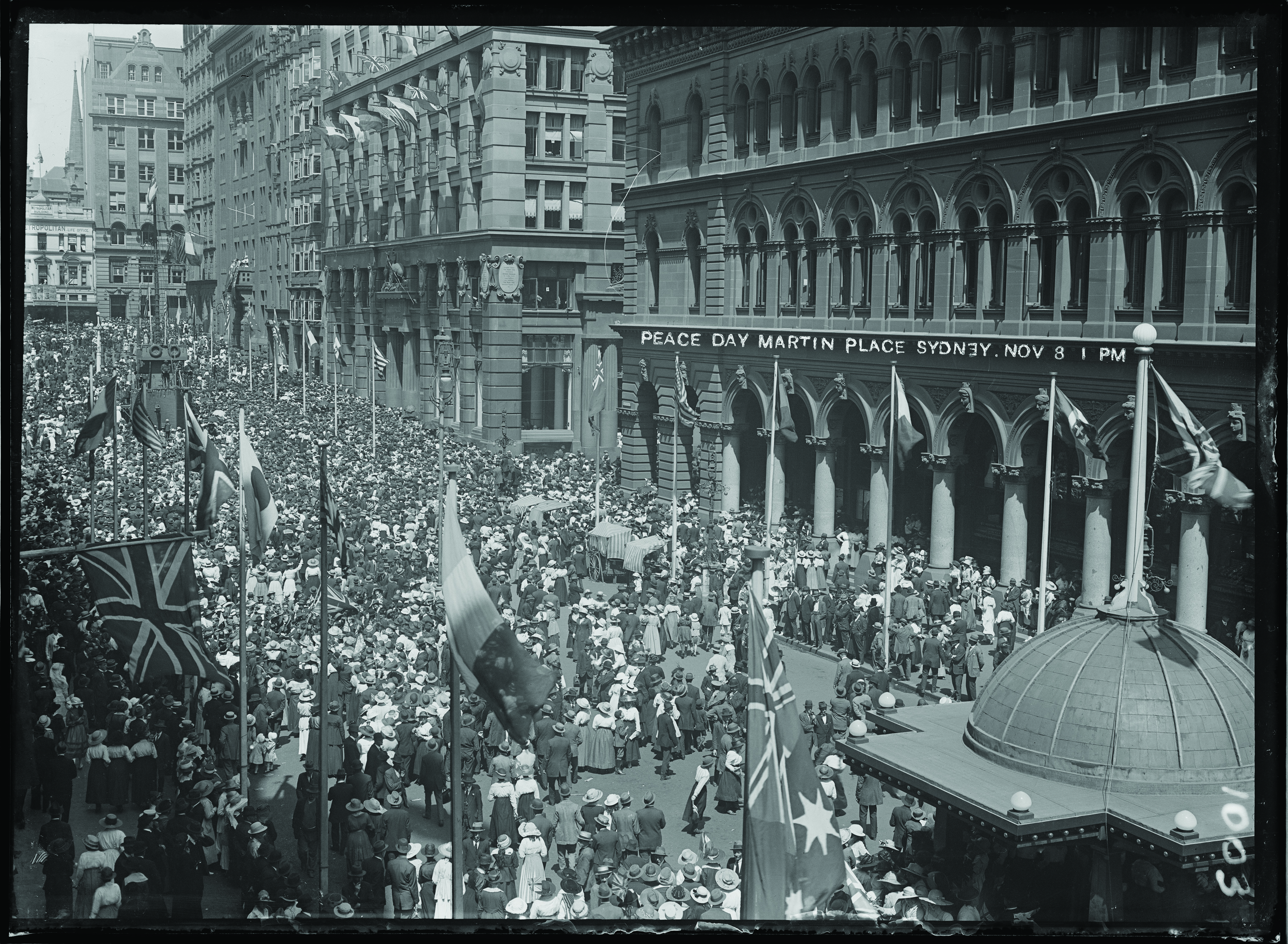The Sun printed this photograph of a 'Carnival of Peace' where thousands gathered in Martin Place. Allies' flags hang from poles edging the public space