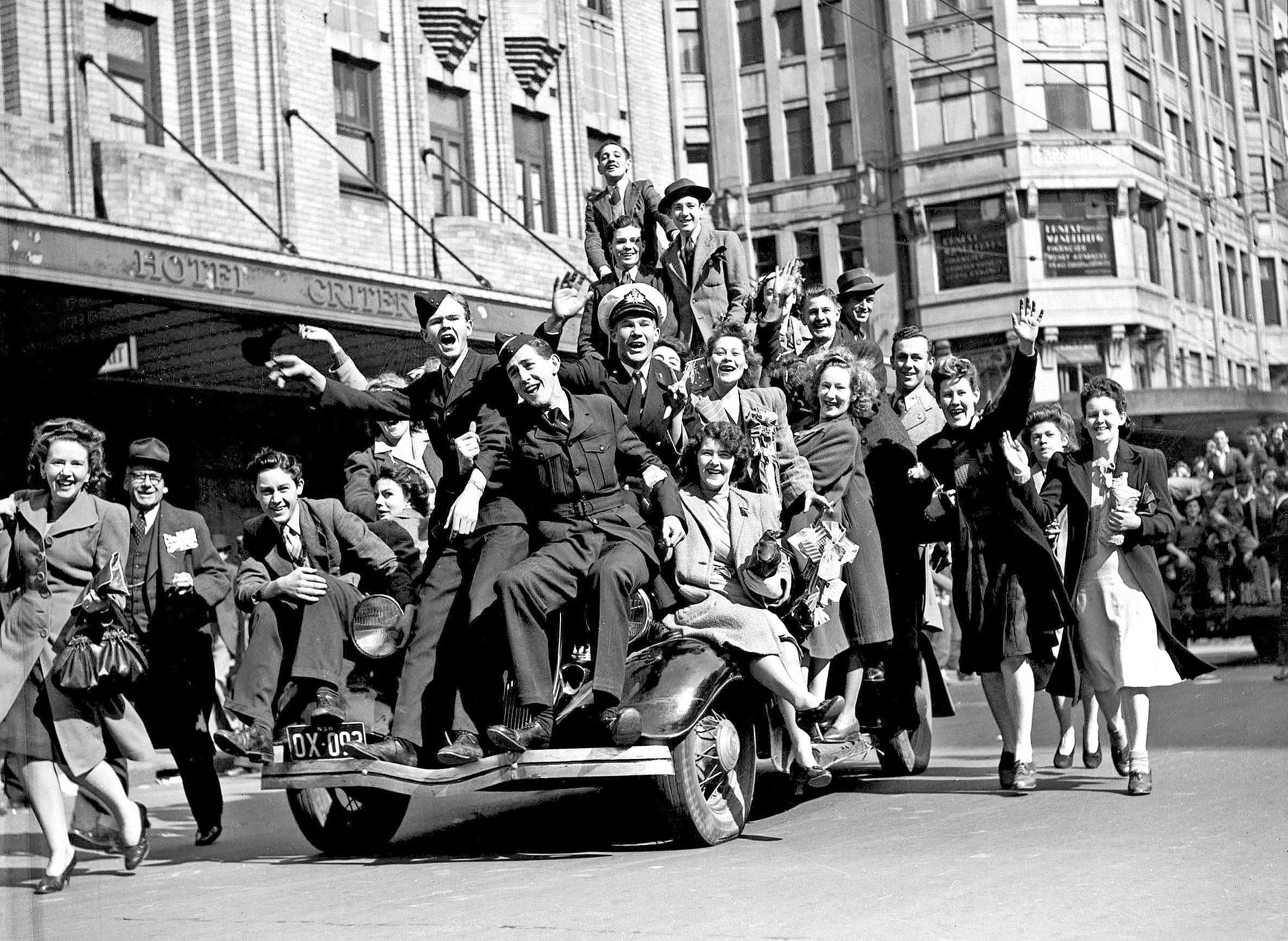 Two airmen and a merchant naval officer join civilian revellers and pile on to a car in Sydney to celebrate the announcement of Japan's surrender in August 1945. Courtesy of the Sydney Morning Herald