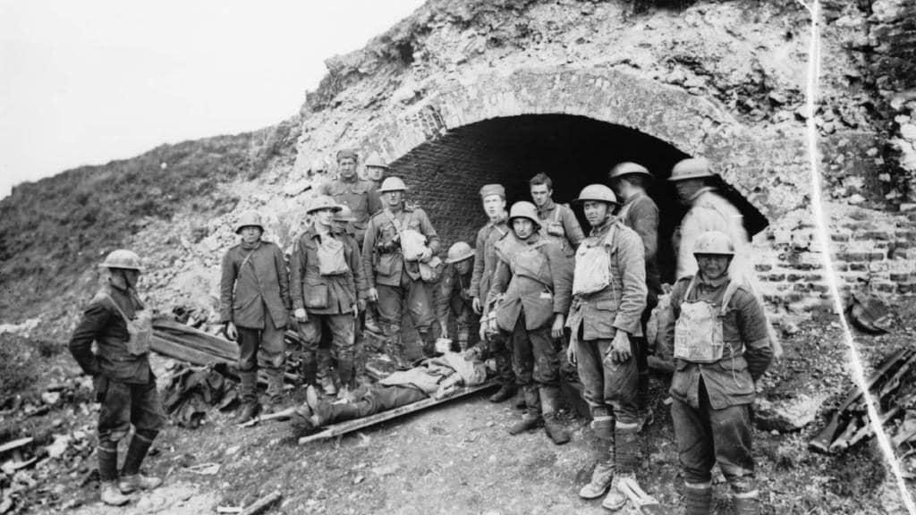 Australian soldiers from the 60th Battalion with American stretcher bearers and German prisoners including one wounded man at one of the entrances to the  St Quentin Canal Tunnel, part of the Hindenburg Line Defences, 1 October 1918. Courtesy AWM