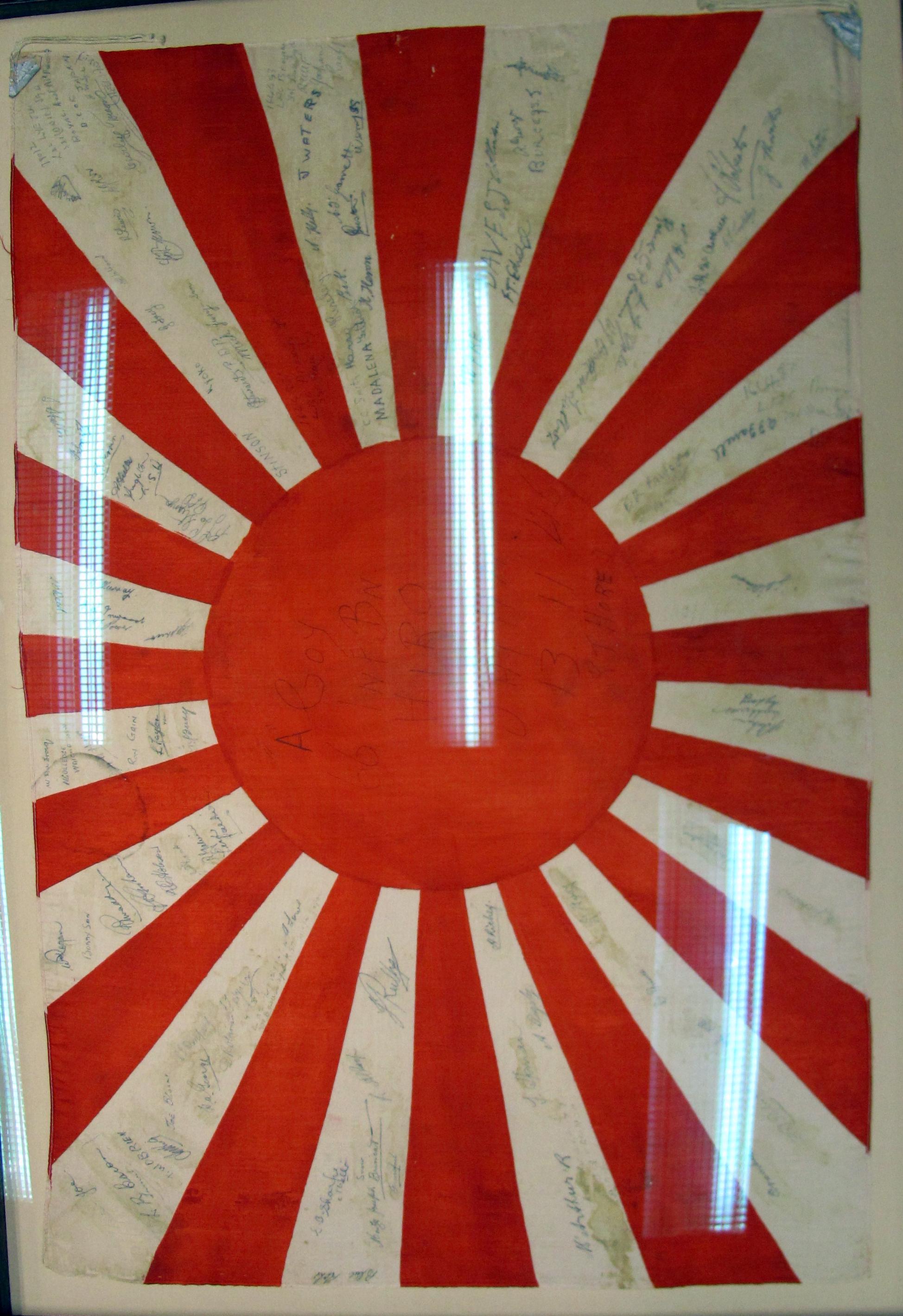 This Japanese flag was taken from the ruins of the Japanese naval arsenal at Hiro by Private Ray Hore and his mates from the 66th Battalion, BCOF. The flag is signed by the men of A Company and a few RAAF personnel. 