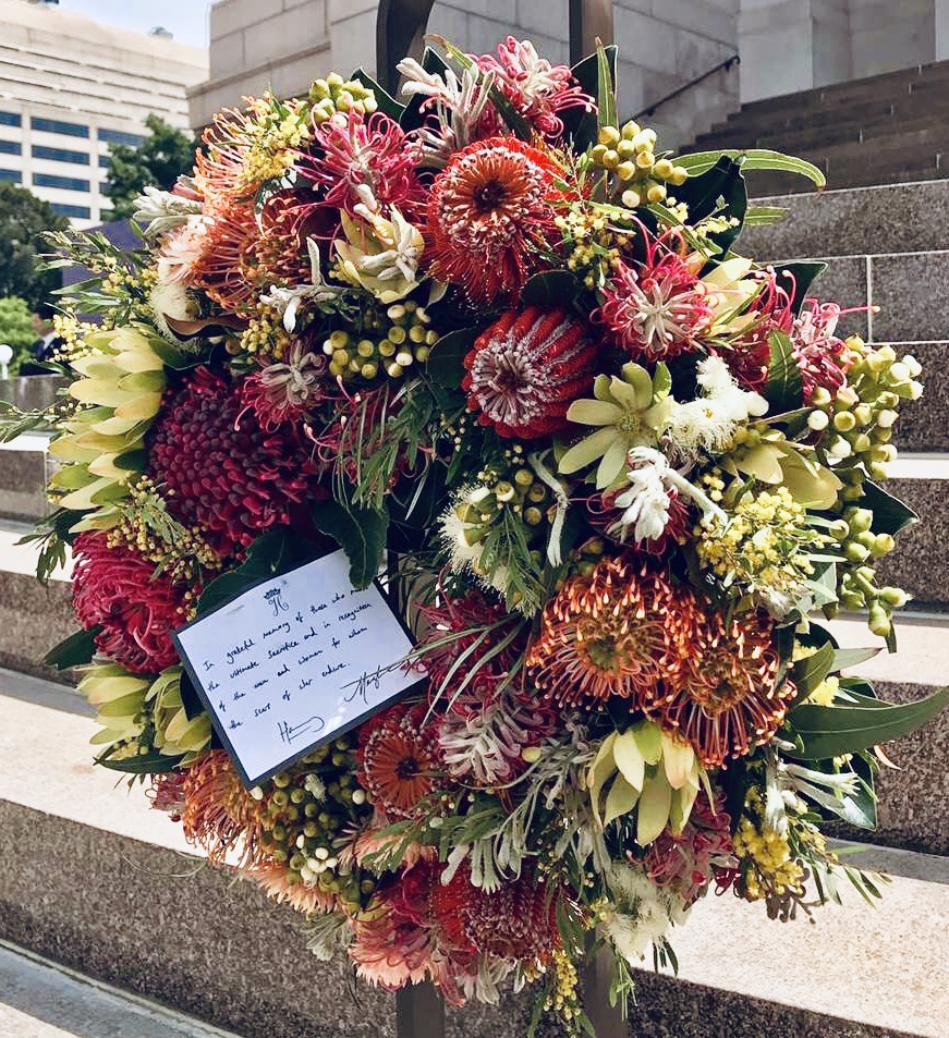 The wreath of Australian natives laid by the Duke and Duchess of Sussex. The accompanying card reads: In grateful memory of those  who made the ultimate and in recognition of the men and women for whom the scars of war endure. Harry Meghan 