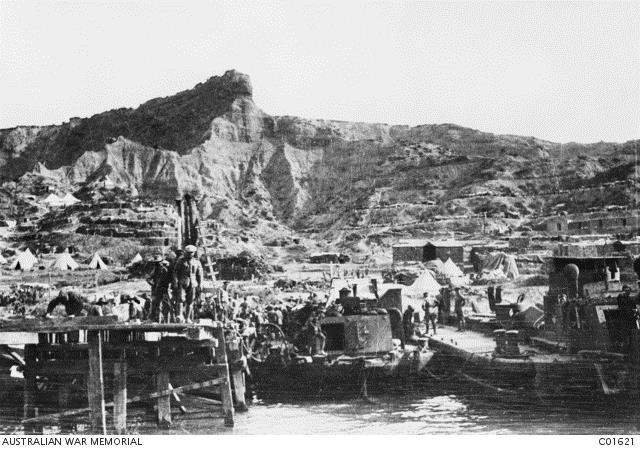 Williams’ Pier at North Beach, one of the main piers used for evacuation operations in December 1915 with the well-known feature of The Sphinx in the background and terraced dugouts in the adjacent hillside. Courtesy AWM