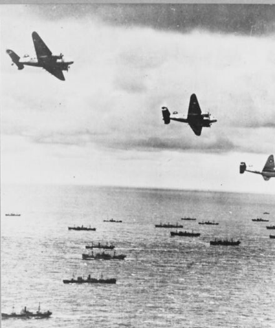 Hudson aircraft of the Coastal Command, on anti-submarine patrol, fly over part of a convoy on its way to England. IWM CH 2859.