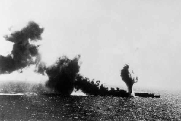 Coral Sea. 1942-0507. The Japanese aircraft carrier SHOHO under attack by United States Navy aircraft during the battle of the Coral Sea. The attack commenced at 1100, abandon ship was ordered at 1131, and the SHOHO sank within 5 minutes. This photograph shows a torpedo exploding on the starboard side. (US Navy photo no. 11497). AWM 157892.