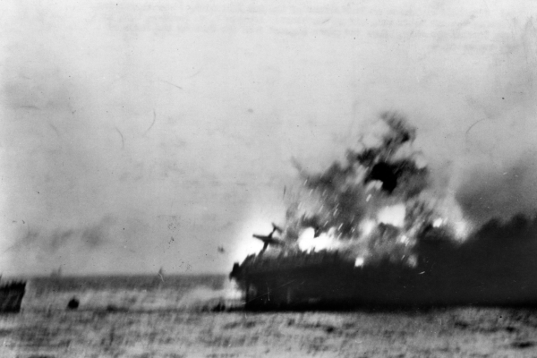 A heavy explosion on board USS LEXINGTON (CV-2) blows an aircraft over her side, 8 May 1942. At left is the bow of USS HAMMANN (DD-412), which was backing away with a load of the carrier's survivors on board. This view appears to be cropped from Photo # 80-G-7413. Official U.S. Navy Photograph. National Archives. 80-G-11916