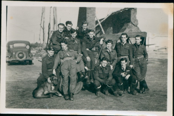 Exhausted pilots from No.3 (fighter bomber) Squadron RAF, including Flying Officer Ron Adcock, pose in front of ruins in Normandy. (Anzac Memorial Collection)