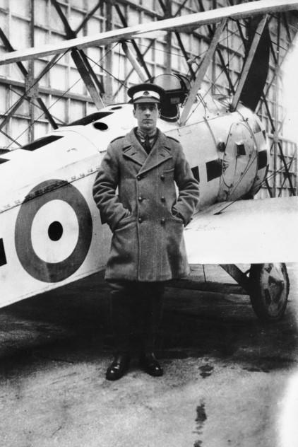An unidentified AFC trainee standing next to the white painted with black check pattern Sopwith Camel aircraft, Serial E7267, which was used by Captain A.H. Cobby DFC, DSO and Bars, of No. 4 Squadron, AFC, while serving as an instructor with No 8 (Training) Squadron at Leighterton aerodrome in England. AWM A04093.