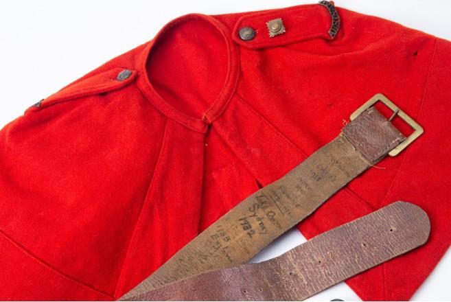 Red wool cape and brown leather belt belonging to Florence McMillan.