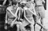 Five Australian former POWs relax with cups of tea and a newspaper after the Japanese surrender. Their thin bodies show the physical effects of captivity. (Courtesy of the Australian War Memorial