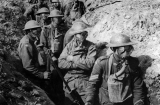 Wearing their box respirators as protection against poison gas, men of the NSW-raised 14th Brigade pose for a photograph by Frank Hurley the day after the capture of Polygon Wood. Note the German pillbox in the background. National Library of Australia. 