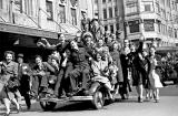 Two airmen and a merchant naval officer join civilian revellers and pile on to a car in Sydney to celebrate the announcement of Japan's surrender in August 1945. Courtesy of the Sydney Morning Herald